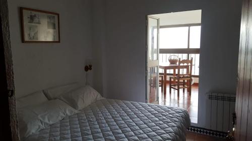 サアラ・デ・ラ・シエラにあるLos Estribosのベッドルーム1室(ベッド1台付)、バルコニーへのドアが備わります。