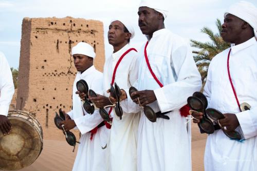 a group of men standing in front of a building at Bivouac Joudour Sahara in Mhamid