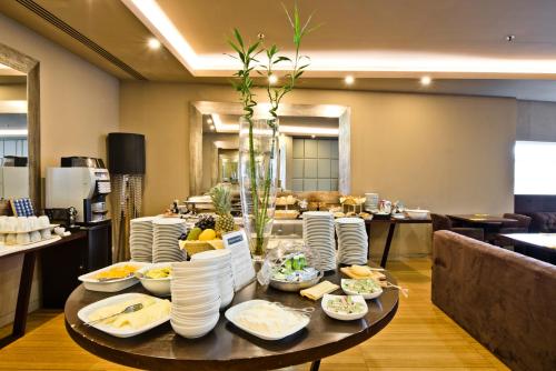 a table with plates and bowls of food on it at Golden Tulip São João da Madeira in São João da Madeira