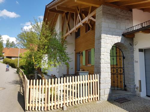 a fence in front of a house with a gate at Ferienwohnung Am Kirchberg in Achslach