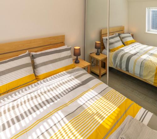 a bedroom with two beds and two mirrors at The Bake House in Worthing
