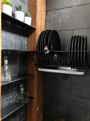 a kitchen with black shelves with plates on them at Clockhouse Cottage in Saulkrasti