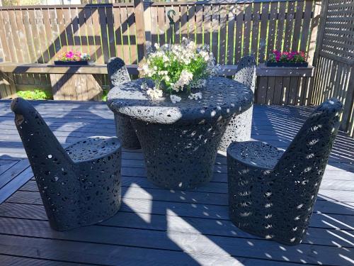 a table and chairs with a potted plant on a deck at Clockhouse Cottage in Saulkrasti