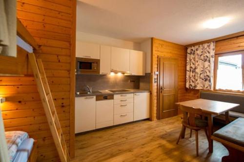 a kitchen with a table and a wooden wall at Ferienhaus Nickl in Weissbriach