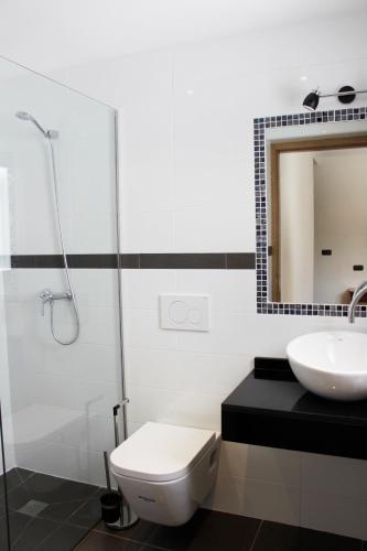 a bathroom with a toilet and a sink and a mirror at The Villa by Albir Proper Properties in Albir