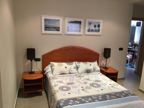 a bedroom with a bed and two night stands with lamps at The Villa by Albir Proper Properties in Albir