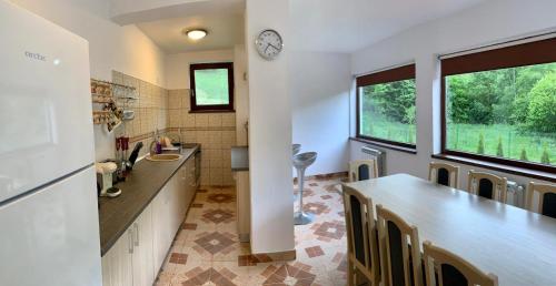 eine Küche mit einer Theke und einer Uhr an der Wand in der Unterkunft Cabana Nisipoasa in Râu de Mori