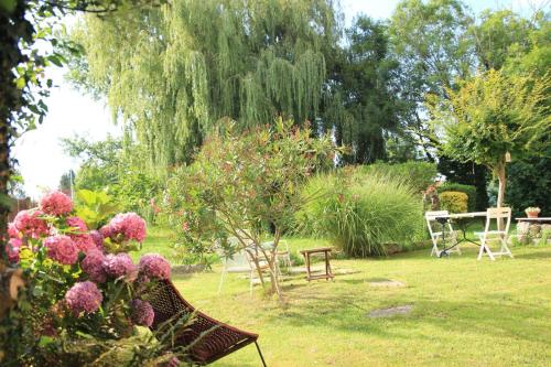 a garden with a bench and a table and a tree at La Ventanita Del Campo in La Cavada