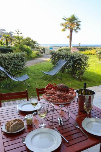 a table with plates of food and glasses of wine at Superbe appart.T2 face à la mer à Tréboul Douarnenez in Douarnenez