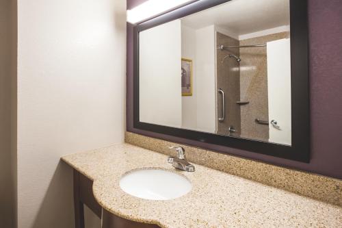 a bathroom with a sink and a large mirror at La Quinta Inn by Wyndham Waldorf in Waldorf