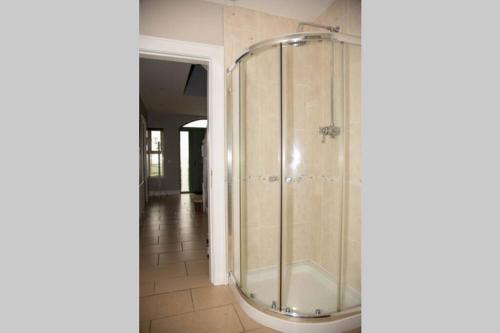 a glass shower in a bathroom with a tile floor at Hillside House- Wild Atlantic Way in Burnfoot