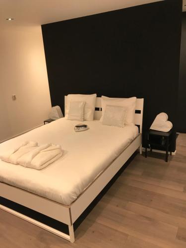 ein Bett mit weißer Bettwäsche und weißen Kissen darauf in der Unterkunft Hofstee appartement. in Urk