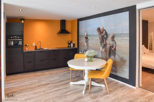a kitchen and dining room with a painting on the wall at Gastenverblijf de paddestoel in Urk