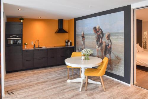 a kitchen and dining room with a painting on the wall at Hofstee appartement. in Urk