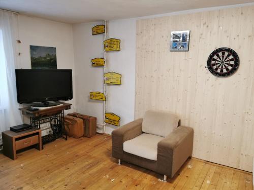 a living room with a chair and a flat screen tv at Vila Valéria in Vysoke Tatry - Tatranska Lomnica.