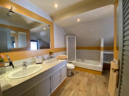 a bathroom with two sinks and a toilet and a tub at Villa Blanca con piscina a 15 minutos de Toledo in Olías del Rey