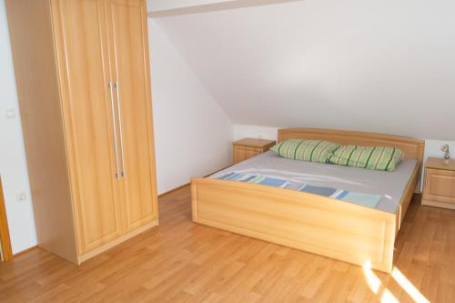 1 dormitorio con cama de madera y armario en house on the top of the hill, en Mozirje