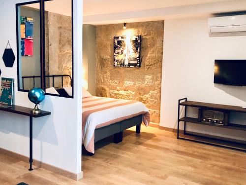 a bedroom with a bed and a tv on a wall at Boreal Porto Gaia - Patio & Pool in Vila Nova de Gaia