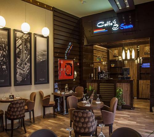 restauracja ze stołami i krzesłami oraz bar w obiekcie Hotel Seever w mieście Irbil