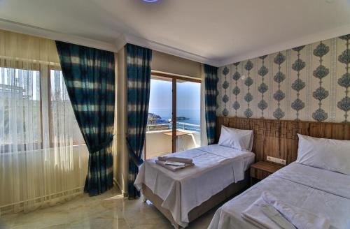 a hotel room with two beds and a large window at Amasra Sunrise Otel in Bartın