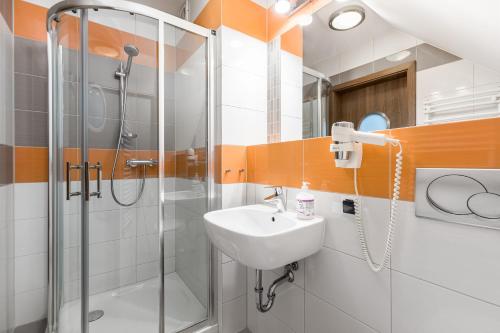 a bathroom with a sink and a shower at Pokoje Palicki in Dźwirzyno