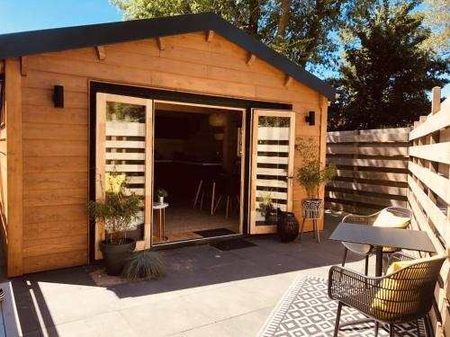 a small shed with a patio with a table and chairs at LODGE 5 Zandvoort in Zandvoort