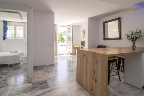 a kitchen and living room with a wooden counter top at Casa Aguila Ibiza in Cala Vadella