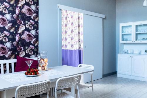 jadalnia ze stołem i krzesłami z kwiatową ścianą w obiekcie Apartament pod Morwą w Lubniewicach