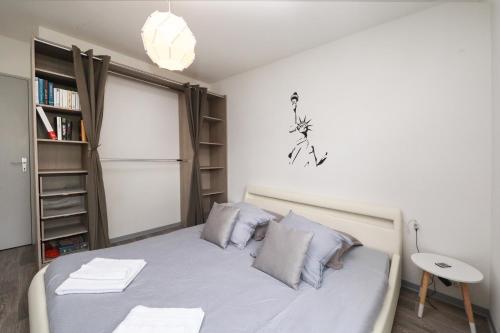 een kleine slaapkamer met een bed en een boekenplank bij Ron's Apartment in Colmar