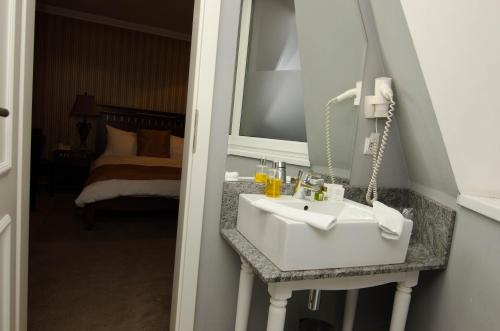 a bathroom with a white sink and a mirror at Hotel Boutique Monaco in Bucharest