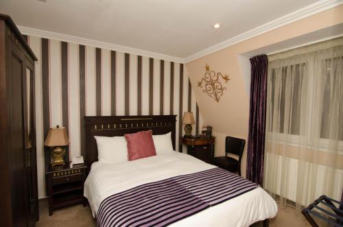 a bedroom with a bed with a black and white stripes at Hotel Boutique Monaco in Bucharest