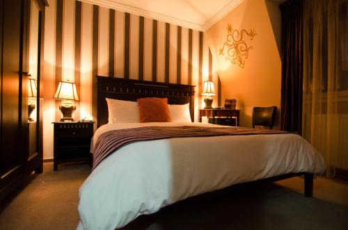 a bedroom with a large bed with two lamps on it at Hotel Boutique Monaco in Bucharest