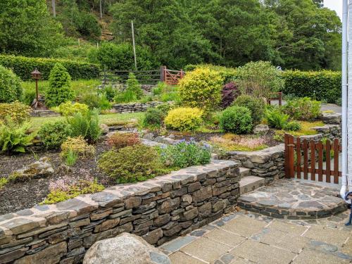 a garden with a stone wall and some plants at The Haven in Keswick