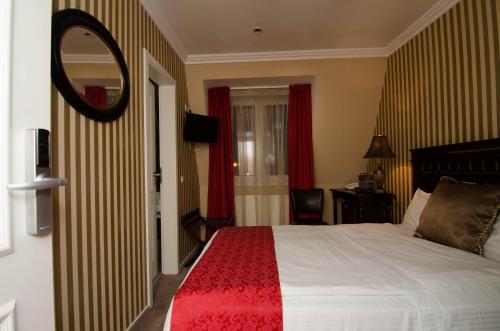 a hotel room with a bed and a mirror at Hotel Boutique Monaco in Bucharest