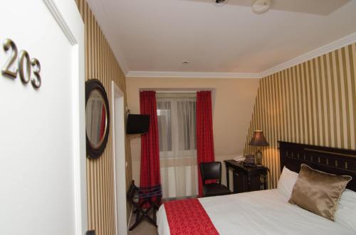 a bedroom with a bed and a desk and a chair at Hotel Boutique Monaco in Bucharest