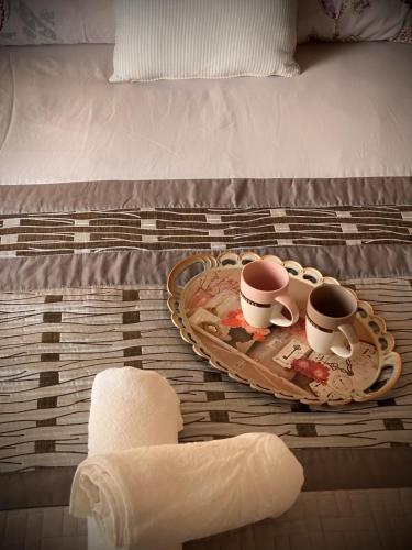 a tray with three coffee cups on a bed at Kallithea studio in Kallithea Halkidikis