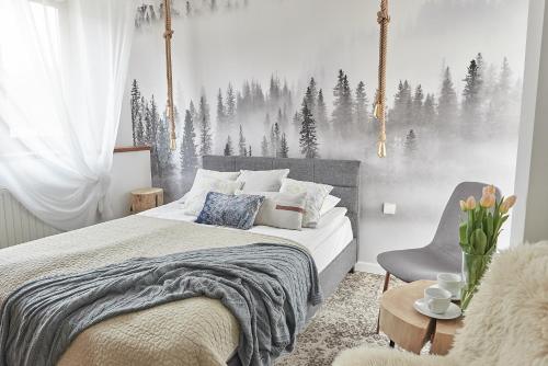 1 dormitorio con 1 cama y una escena de invierno en la pared en Willa Piano, en Zakopane