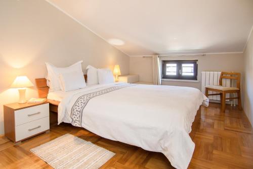 a bedroom with a large white bed and a window at Apartments Dora in Poreč