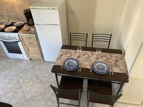 a kitchen with a table with chairs and a refrigerator at Kallithea studio in Kallithea Halkidikis