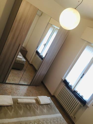 an attic room with two windows and a mirror at B&B dell'Amicizia in Fano
