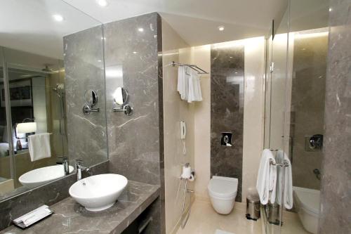 a bathroom with a sink and a toilet and a shower at Crowne Plaza Pune City Centre by IHG in Pune
