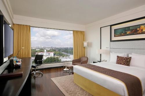 a hotel room with a bed and a large window at Crowne Plaza Pune City Centre by IHG in Pune