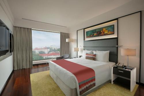 a hotel room with a large bed and a large window at Crowne Plaza Pune City Centre by IHG in Pune