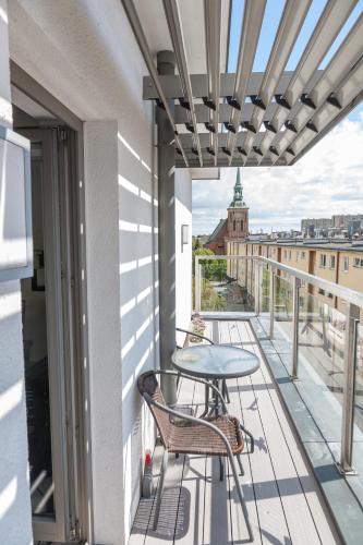 a patio with a table and chairs on a balcony at Apartamenty Gdańsk EU - Waterlane in Gdańsk