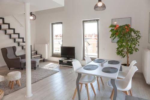 a white living room with a table and chairs at Apartamenty Gdańsk EU - Waterlane in Gdańsk