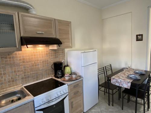 a kitchen with a white refrigerator and a table with chairs at Kallithea studio in Kallithea Halkidikis