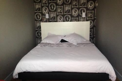 un lit avec des draps blancs et des oreillers dans une chambre dans l'établissement Rue d'Isly, à Rennes