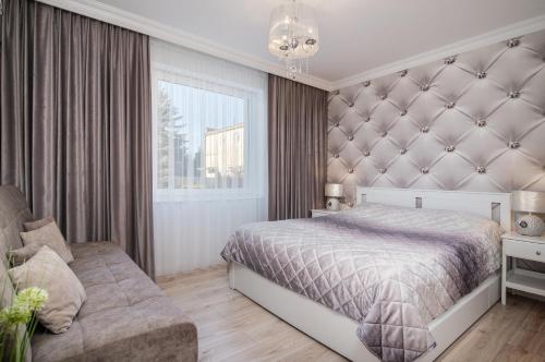 um quarto com uma cama grande e um sofá em Apartamenty Relax em Władysławowo