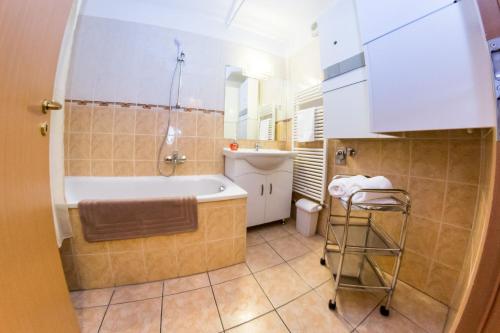 a bathroom with a tub and a sink at Arpad Bridge Apartments in Budapest