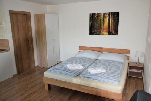 a bedroom with a bed with two towels on it at ADEMI Apartments in Smrečany